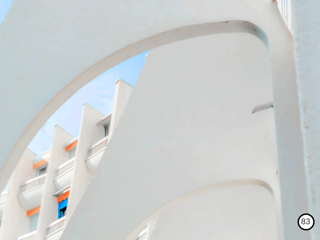photo en contre plongé d'un bâtiment blanc avec une architecture en voute à la grande motte