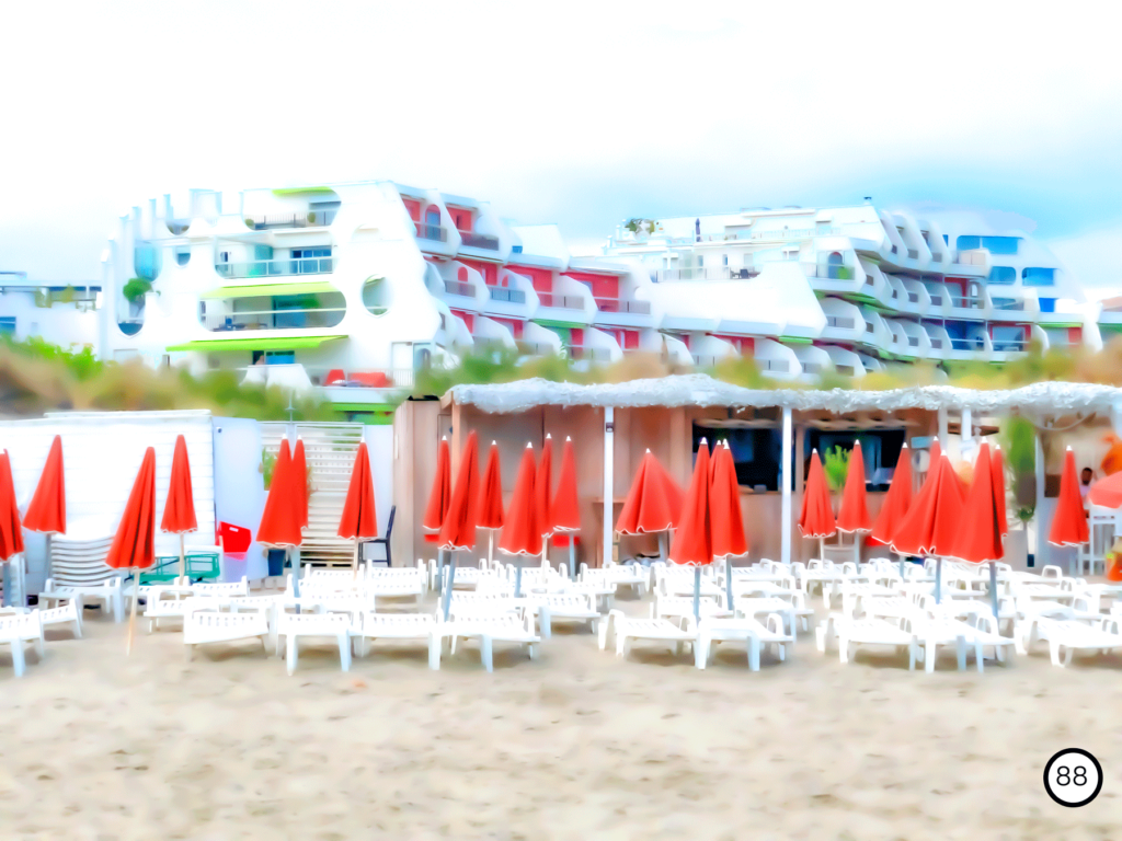 Photo de la plage de la grande motte Avec des bâtiments blanc et parasols rouges