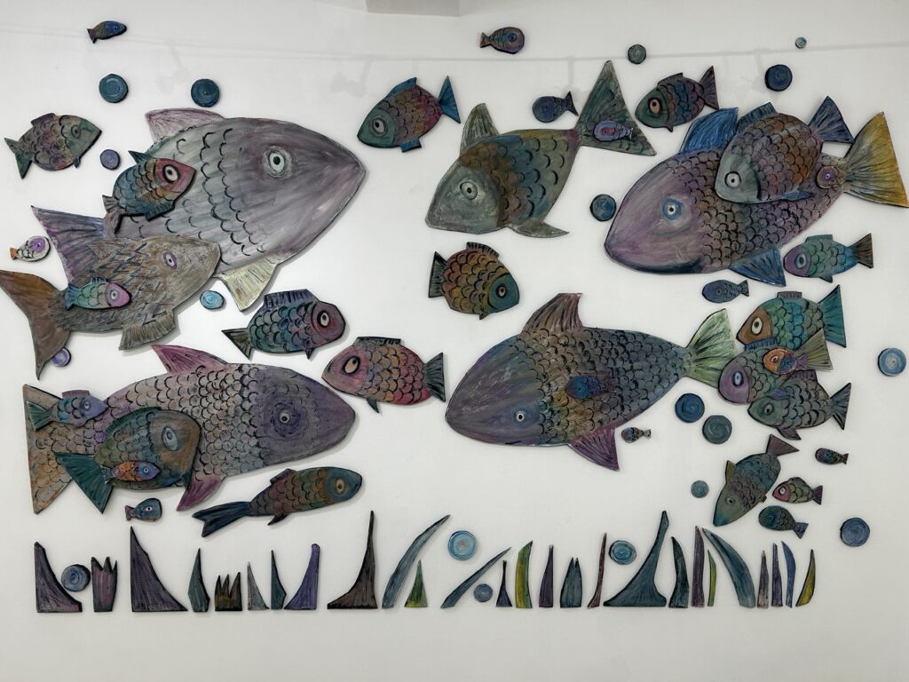 Collage de poisson en carton sur un mur blanc
